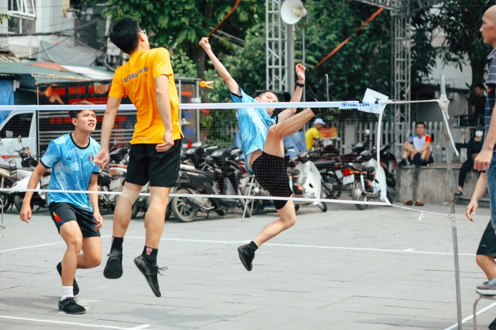 Dynamic shot of young men playing badminton on a vibrant street.